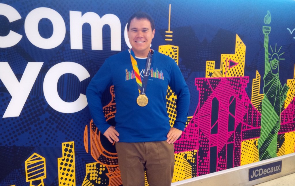 Posing with my medal and race shirt at the airport