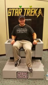 In a Star Trek captain's chair made of Mega Blocks. It's a shame I had the wrong shirt on...